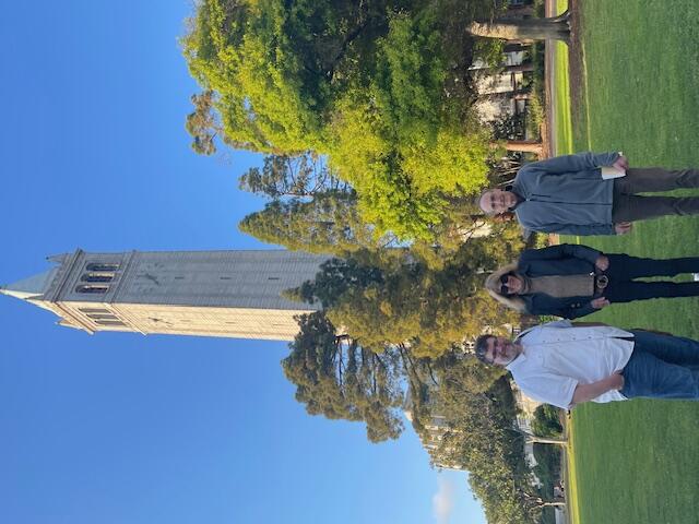 Image showing author Joy Williams with chair Prof Eric Falci and Jon Bedri in front of campanile with trees in background